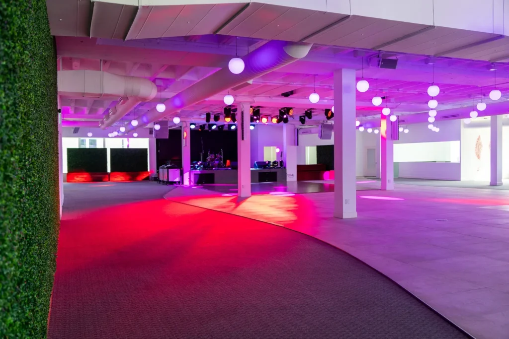 Dallas event venue - Imagen's spacious dance floor framed by a lush artificial leaf wall