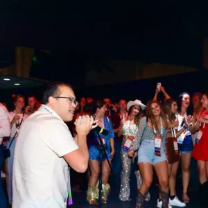 Guest singing karaoke while audience cheers at Imagen Venues corporate event venue in Houston