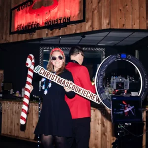 Guest posing with Christmas props at the 360 photo booth during a holiday party at Imagen Venues in Houston