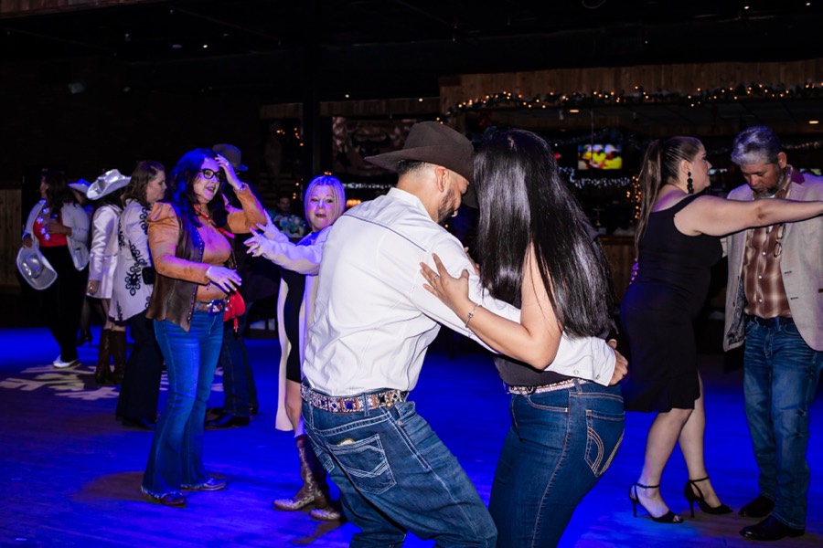 Couples dancing under blue lighting at a company holiday party at Imagen Venues