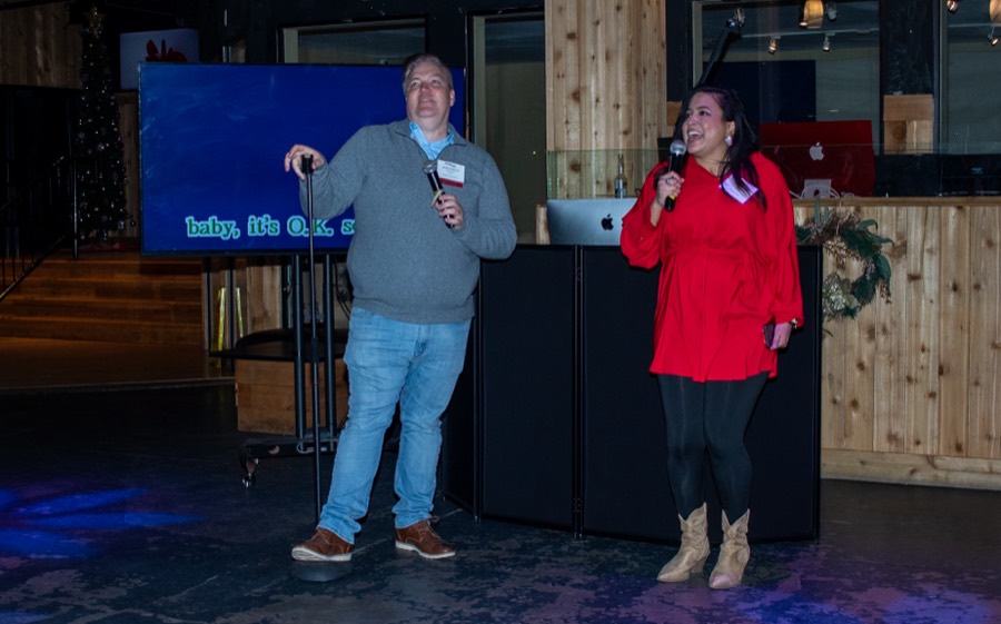 Coworkers singing karaoke at a company holiday party at Imagen Venues in Houston