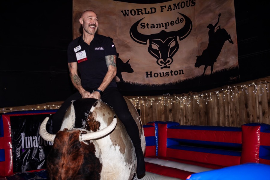 Guest riding the mechanical bull at a holiday party at Stampede Event Center
