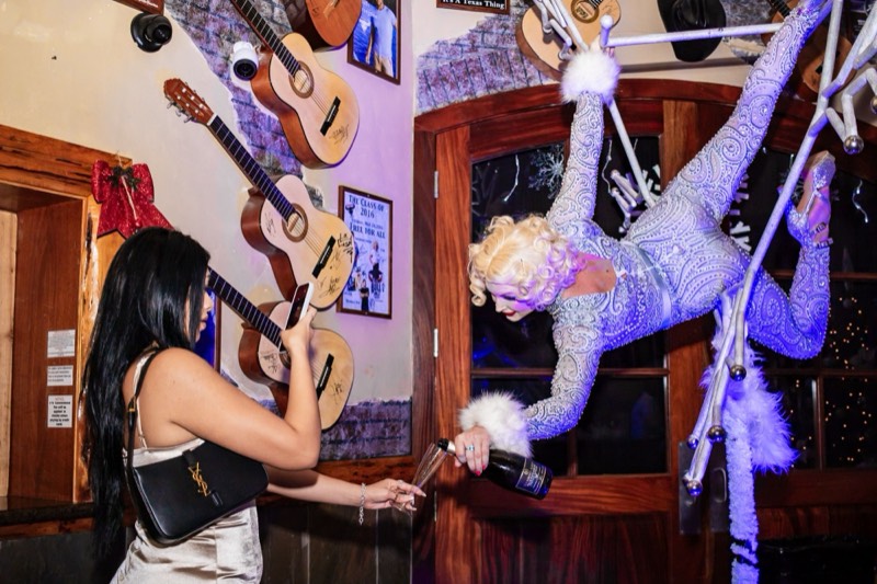 Aerialist pouring champagne from the ceiling at a company holiday party